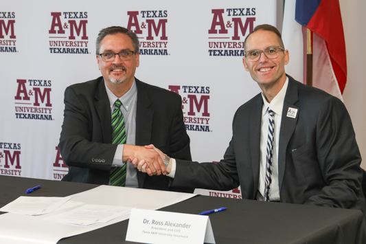 PJC President Dr. Stephen Benson (left) and A&M-Texarkana President Dr. Ross Alexander shake hands after signing a new partnership between the two institutions.